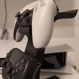 black 3-in-1 PS5 and Xbox Controller Stand – Compatible with PlayStation 5/Xbox Consoles. A gaming desktop organizer with a headphone hanger, non-charging base that holds 2 controllers and headphones. Space-saving white/black console accessory.