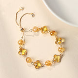 Silver-tone bolo bracelet with clear quartz beads and four-leaf clover charms.