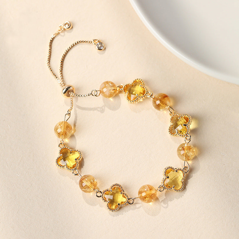 Silver-tone bolo bracelet with clear quartz beads and four-leaf clover charms.