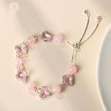 Silver-tone bolo bracelet with clear crystal beads and four-leaf clover charms.