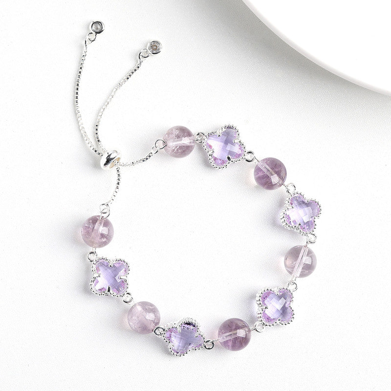 Silver-tone bolo bracelet with clear crystal beads and four-leaf clover charms.
